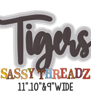 May include: A decorative sign with the word "Tigers" in a dark gray script font, outlined in white and gray. Below, the text "SASSY THREADZ" is displayed in colorful, marquee-style letters. The sign is available in 11", 10", and 9" widths.