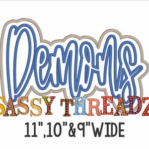 Op de afbeelding: Op een witte achtergrond staat het woord "Demons" in blauw script, omlijnd met grijs. Daaronder staat "Sassy Threadz" in kleurrijke, patroonletters. De tekst "11", 10" & 9" WIDE" staat onderaan.