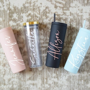 May include: Four personalized tumblers with names "Jennifer", "Samantha", "Allison", and "Kristina" written in white script. The tumblers are in pink, clear, black, and light blue.