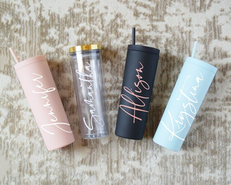 May include: Four personalized tumblers with names "Jennifer", "Samantha", "Allison", and "Kristina" written in white script. The tumblers are in pink, clear, black, and light blue.