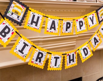 May include: A yellow and black banner with the words "Happy Birthday" in black letters. The banner is decorated with school bus and school supply themed patterns.