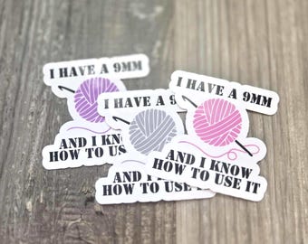 May include: A collection of white stickers with text and graphics related to crochet. Each sticker features the phrase "I HAVE A 9MM" above a yarn ball and crochet hook design, with the text "AND I KNOW HOW TO USE IT" below.
