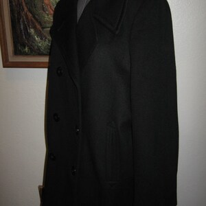 May include: A black peacoat with a double-breasted closure and a single pocket on the left side.