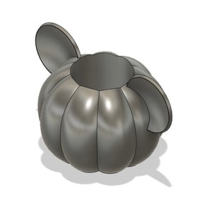 May include: A gray ceramic pumpkin-shaped container with two ear-like handles. The container has a smooth, rounded surface and a wide opening at the top.