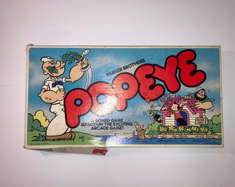May include: Vintage Popeye board game box. The box art shows Popeye, Olive Oyl, and other cartoon characters. The word "POPEYE" is in large red letters. The text "A BOARD GAME BASED ON THE EXCITING ARCADE GAME!" is also visible.