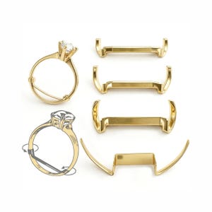 May include: A gold-colored ring with a large, clear gemstone, shown with several gold ring sizers. An illustration of the ring is also included. The ring sizers are in various sizes and shapes.