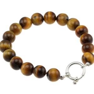 Puede incluir: Un brazalete de piedra de ojo de tigre marrón con un cierre de plata.