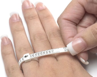 May include: A white ring sizer tool is wrapped around a finger. The tool has a sliding scale with numbers from 1 to 17, and an arrow indicating the ring size. The tool is used to measure finger size for rings.