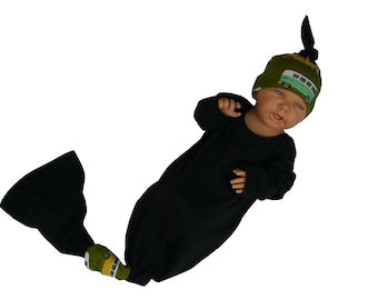 May include: A black baby gown with a green and yellow bus pattern on the feet and a matching green and yellow bus pattern hat with a black knot on top.