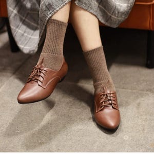 May include: A set of three ceramic mugs with a speckled, matte finish in cream, light grey, and dark grey. Each mug has a minimalist design, ideal for tea or coffee.