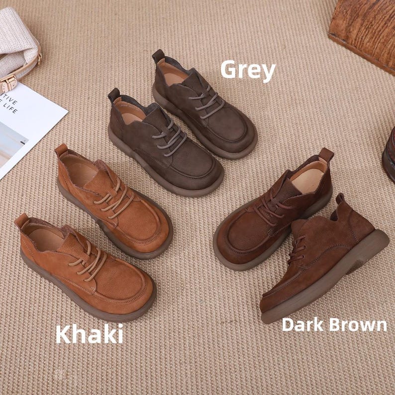 May include: A selection of leather shoes in shades of grey, khaki, and dark brown. The shoes feature a traditional lace-up style and a rounded toe. The image is labelled with the shoe colours.