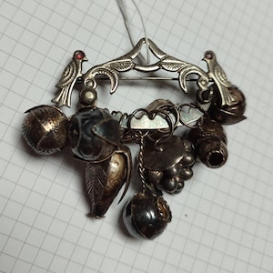 Si apre un'antica Penca de Balangandan. Enorme amuleto. Antica Penca brasiliana. Marcatura sul retro, fogliame, 2 uccelli dagli occhi di rubino, 8 ciondoli.