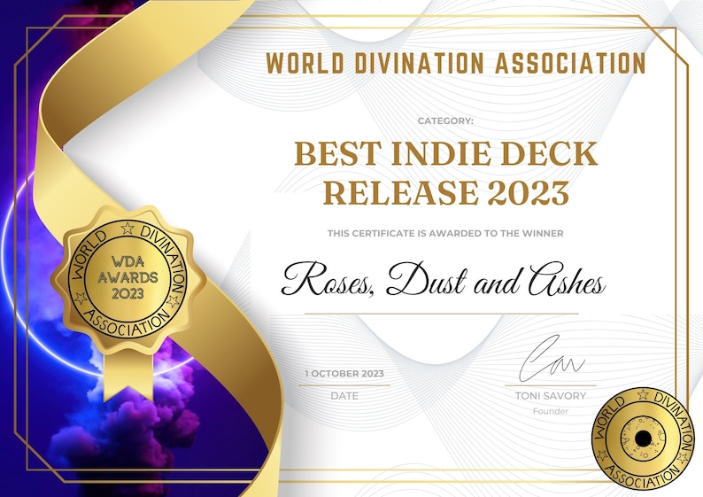 Może przedstawiać: Złoty certyfikat z białym tłem i czarnym tekstem. Certyfikat zawiera napis "World Divination Association" i "Best Indie Deck Release 2023". Certyfikat został przyznany dla "Roses, Dust and Ashes".
