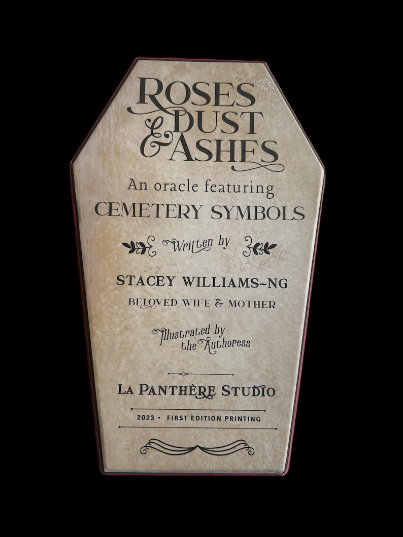 Może przedstawiać: Beżowe pudełko w kształcie trumny z czerwoną obw&oacute;dką. Pudełko ma vintage'owy wygląd i zawiera tekst "Roses & Dust & Ashes" w czarnym piśmie. Tekst "An oracle featuring Cemetery Symbols" r&oacute;wnież jest w kolorze czarnym. Tekst "Written by Stacey Williams-Ng Beloved Wife & Mother" r&oacute;wnież jest w kolorze czarnym. Tekst "Illustrated by the Authoress" r&oacute;wnież jest w kolorze czarnym. Tekst "La Panthere Studio 2023 - First Edition Printing" r&oacute;wnież jest w kolorze czarnym.