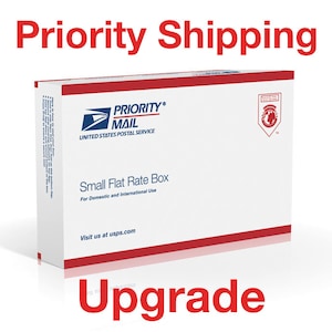 May include: A white USPS Priority Mail Small Flat Rate Box with red and blue accents. The box features the USPS logo and text that reads "Priority Mail" and "Small Flat Rate Box". The words "Priority Shipping" and "Upgrade" are also displayed.