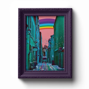 May include: A framed print of a colorful rainbow over a narrow alleyway with buildings on either side. The buildings are a teal blue color and have string lights hanging from them. The alleyway is paved with cobblestones and there is a sign that says "BUFF" on one of the buildings.