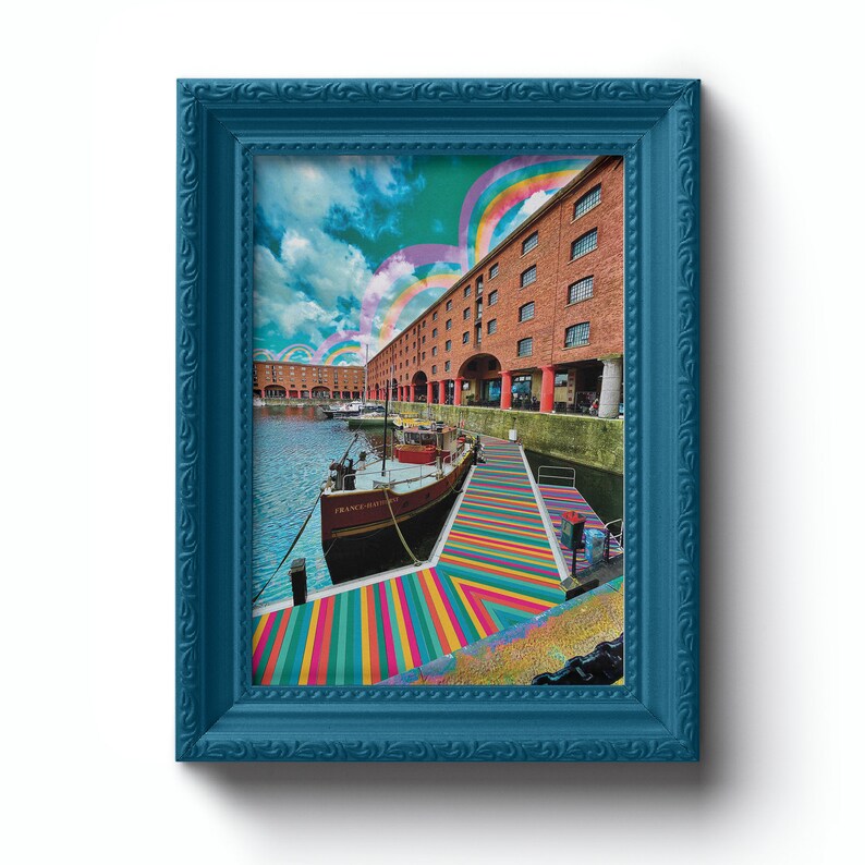 May include: A framed photograph of a boat docked in a harbor with a colorful striped walkway leading to it. The building behind the boat has a red brick facade and a rainbow archway in the sky above.