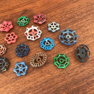May include: Assortment of vintage metal water valve handles in various colors, including red, blue, green, and black. The handles have a starburst design and are perfect for crafting projects.