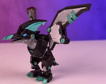 May include: A black and teal robot toy with wings in a bird-like pose. The robot has a beak-like head and a long tail.