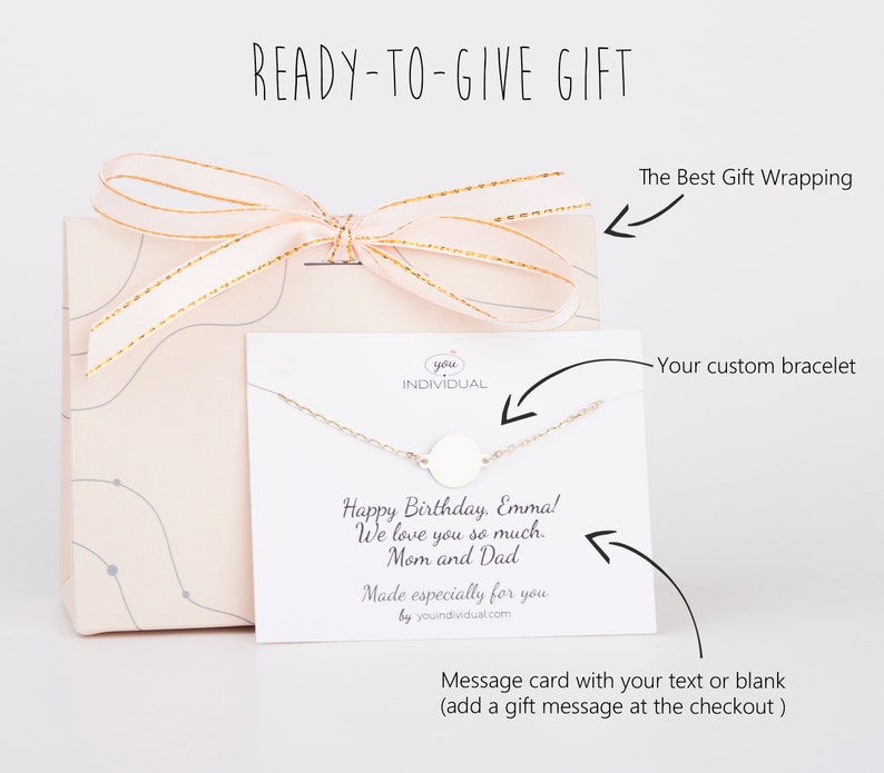 Puede incluir: Una caja de regalo con una cinta rosa y una tarjeta blanca con una pulsera de plata y un mensaje que dice "Feliz cumplea&ntilde;os, Emma! Te queremos mucho. Mam&aacute; y Pap&aacute;. Hecho especialmente para ti por youindividual.com".