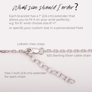 May include: Close-up of a silver cable chain with a lobster claw clasp and a 1 inch (2.6 cm) extender. The chain is labeled "925 Sterling Silver cable chain".