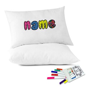 May include: Two white pillowcases with the word "name" printed in colorful, doodle-style lettering. The pillowcases are accompanied by a set of eight colorful markers in a clear plastic case.