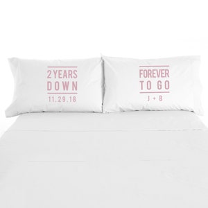 May include: Two white pillowcases with pink text. The left pillowcase says "2 Years Down 11.29.18". The right pillowcase says "Forever To Go J + B".