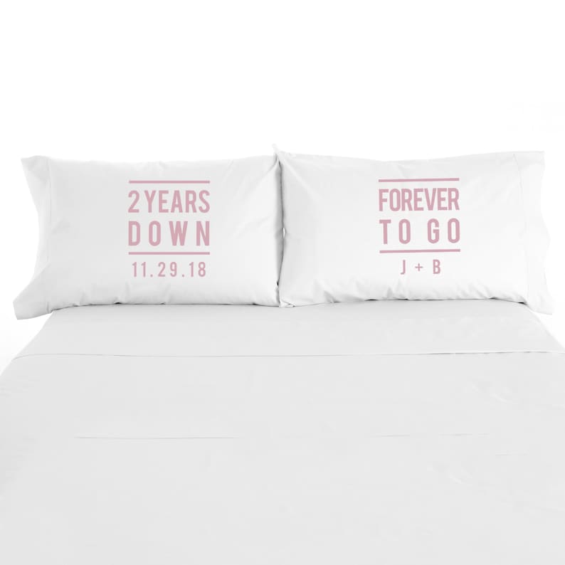 May include: Two white pillowcases with pink text. The left pillowcase says "2 Years Down 11.29.18". The right pillowcase says "Forever To Go J + B".