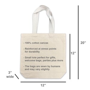 May include: A natural canvas tote bag with a 12-inch width, 20-inch height, and 3-inch depth. The bag features a reinforced design and includes text indicating it's made of 100% cotton canvas.