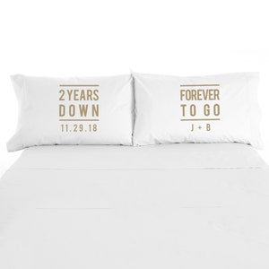 May include: Two white pillowcases with brown text. The pillowcase on the left says "2 Years Down 11.29.18". The pillowcase on the right says "Forever To Go J + B".