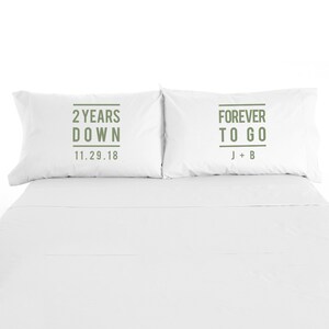 May include: Two white pillowcases with green text. The left pillowcase says "2 Years Down 11.29.18". The right pillowcase says "Forever To Go J+B".