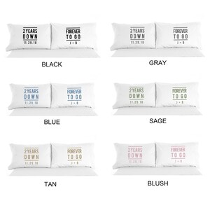 May include: Two white pillowcases with black text. One pillowcase says "2 Years Down 11.29.18" and the other says "Forever To Go J+B". The pillowcases are shown in four different color variations: black, gray, blue, sage, tan, and blush.