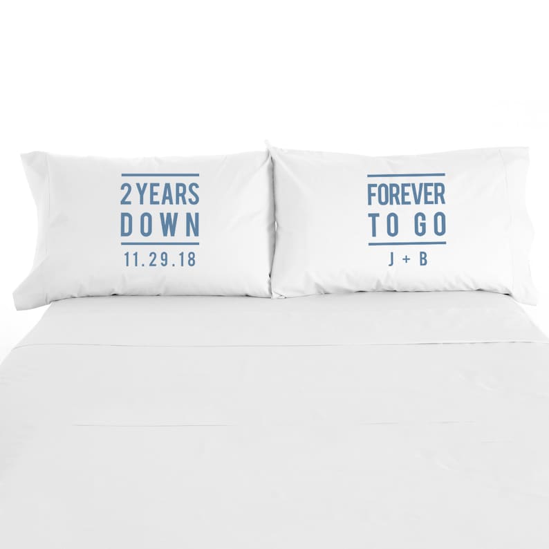 May include: Two white pillowcases with blue text. The left pillowcase says "2 Years Down 11.29.18". The right pillowcase says "Forever To Go J + B".