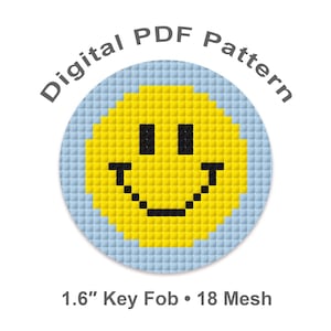 May include: A digital PDF pattern for a key fob. The design features a yellow smiley face with black eyes and a curved mouth, set against a light blue background. The text "Digital PDF Pattern" is arched above the design. The key fob is 1.6 inches in diameter.