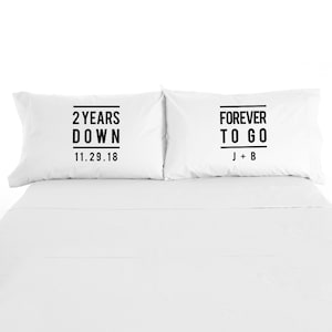 May include: Two white pillowcases with black text. The left pillowcase says "2 Years Down 11.29.18". The right pillowcase says "Forever To Go J+B".