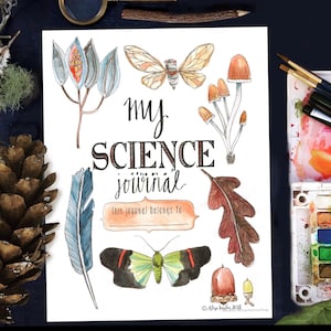 May include: A printable science journal cover featuring watercolor illustrations of a butterfly, mushrooms, an acorn, a feather, a leaf, and a seed pod. The text "my science journal" is written in black cursive lettering. The text "This journal belongs to:" is written in a brown rectangle.