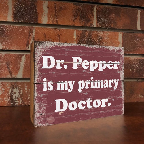 Letrero de madera con el logo de Dr. Pepper de época