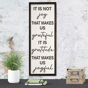 Puede incluir: Un letrero de madera con fondo blanco y texto negro que dice "IT IS NOT joy THAT MAKES US grateful IT IS gratitude THAT MAKES US joyful".