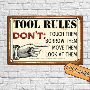 May include: A vintage-style metal sign with a brown border and a white background. The sign reads "TOOL RULES DON'T: TOUCH THEM BORROW THEM MOVE THEM LOOK AT THEM" with a cartoon hand pointing to the right. The text "Proprietor: Rich Johnson" is below the rules. The sign has a distressed, rusty look.
