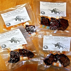 May include: Four clear plastic bags with labels that read "California Blazing Chile Farms Lethal Sriracha Jerky". Each bag contains two pieces of dark brown jerky. The labels feature a skull and crossbones and a bull with a warning about the spiciness of the jerky.