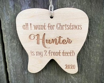 Può includere: Un ornamento di Natale in legno a forma di dente con il testo "all I want for Christmas Hunter is my 2 front teeth 2020".