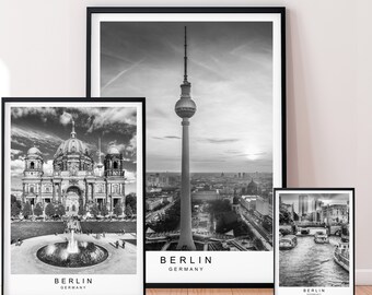 May include: Three framed black and white prints of Berlin landmarks. The images include the Berlin Cathedral, the TV Tower, and a river scene. Each print has the word "BERLIN" and "GERMANY" printed at the bottom.