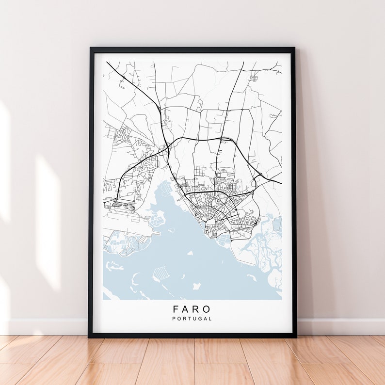 May include: A black and white map print of Faro, Portugal. The map shows the city streets and surrounding area. The city name and country are printed in black at the bottom of the map.
