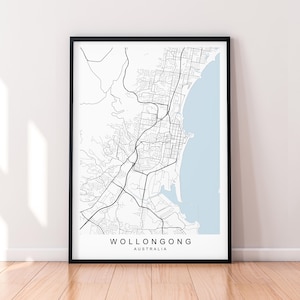 May include: A black and white map print of Wollongong, Australia, with a light blue background. The map shows the city's streets and coastline.