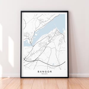 May include: A black and white map print of Bangor, Wales. The map shows the city's streets and waterways. The city name is printed in black at the bottom of the map.
