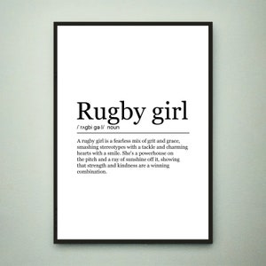 Könnte beinhalten: Schwarzweißes druckbares Wandbild mit einer Definition von "Rugby Girl" als eine furchtlose Mischung aus Mut und Anmut, die Stereotypen mit einem Tackle zerschmettert und Herzen mit einem Lächeln bezaubert. Sie ist ein Kraftpaket auf dem Spielfeld und ein Sonnenstrahl außerhalb, was zeigt, dass Stärke und Freundlichkeit eine gewinnende Kombination sind.