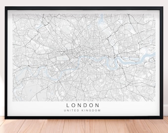 May include: A black and white map of London, United Kingdom, with a light blue river winding through the city. The map is framed in a black frame and is hanging on a white wall.
