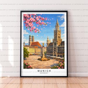 Peut inclure: Une impression d'art encadrée de Munich, en Allemagne, avec une illustration détaillée de l'architecture de la ville. L'œuvre présente le nouvel hôtel de ville, la Frauenkirche et une place centrale, avec des fleurs de cerisier et un ciel bleu. Le texte "MUNICH GERMANY" est en bas.