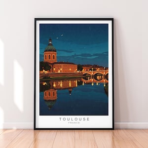 May include: A framed art print featuring a nighttime view of Toulouse, France. The image shows a domed building, a bridge, and their reflections in the water. The print has a black frame and the text "TOULOUSE FRANCE" at the bottom.