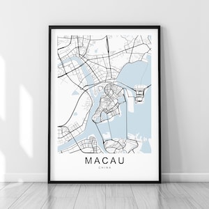 Könnte beinhalten: Eine Schwarzweißkarte von Macau, China, mit blauen Wasserflächen. Die Karte ist in einem schwarzen Rahmen gerahmt und hängt an einer weißen Wand.